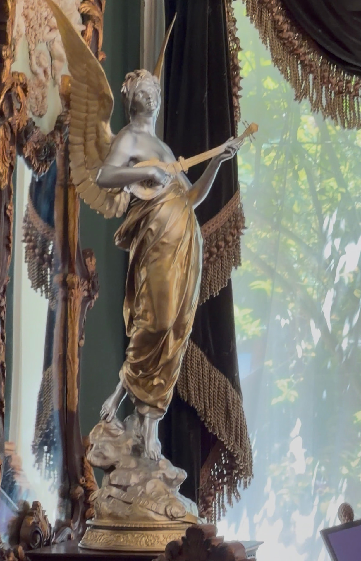 Silver and gold angel sculpture playing a lute inside Universal Sanctuary Church